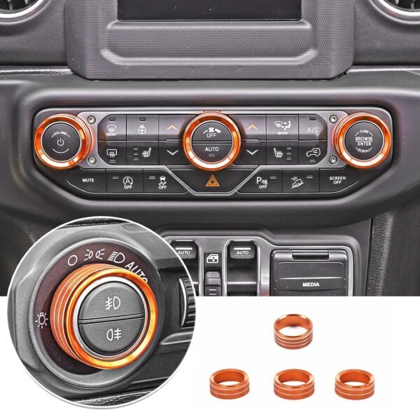 Orange aluminum AC, radio and headlight knob covers installed in a Jeep